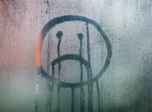 Sad face on steamy window